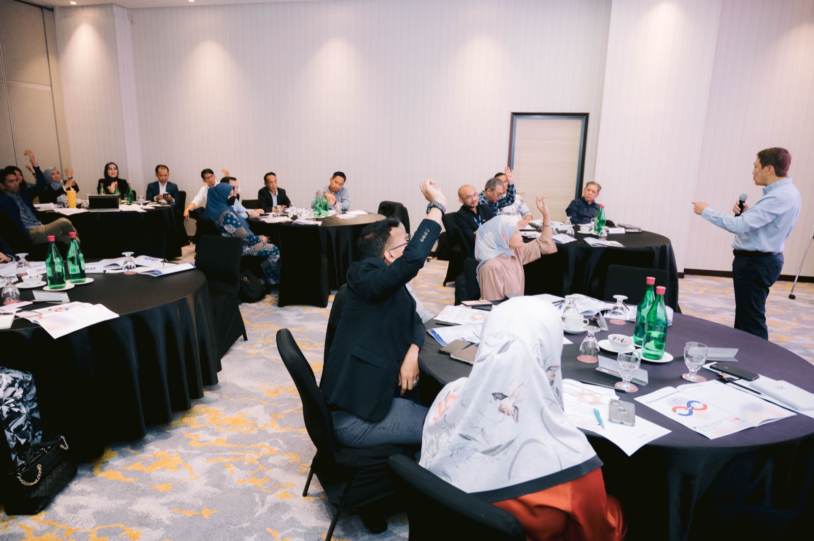 Participants engaging in an Otti training session in Kuala Lumpur, hands raised