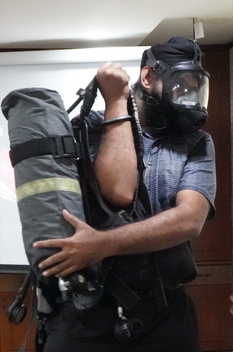 A trainer donning self-contained breathing apparatus during BOMBA fire safety training