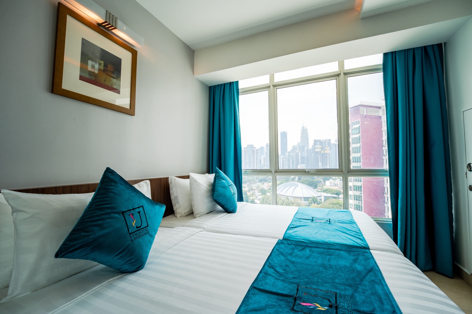 A 4-star twin room at the UTM Kuala Lumpur campus with the KL skyline through the window